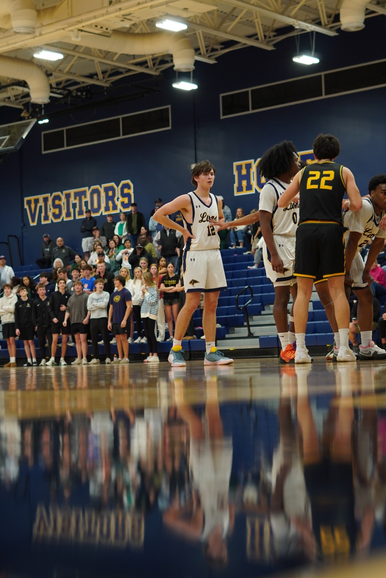 High school basketball game action under arena lights